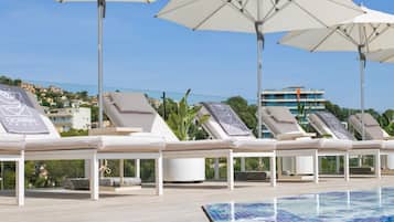 Seasonal outdoor pool, a natural pool, pool umbrellas, sun loungers