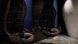 Two wicker chairs with cushions in a dimly lit room with tiled walls and a patterned floor. - The Donna Portals (Calvia)