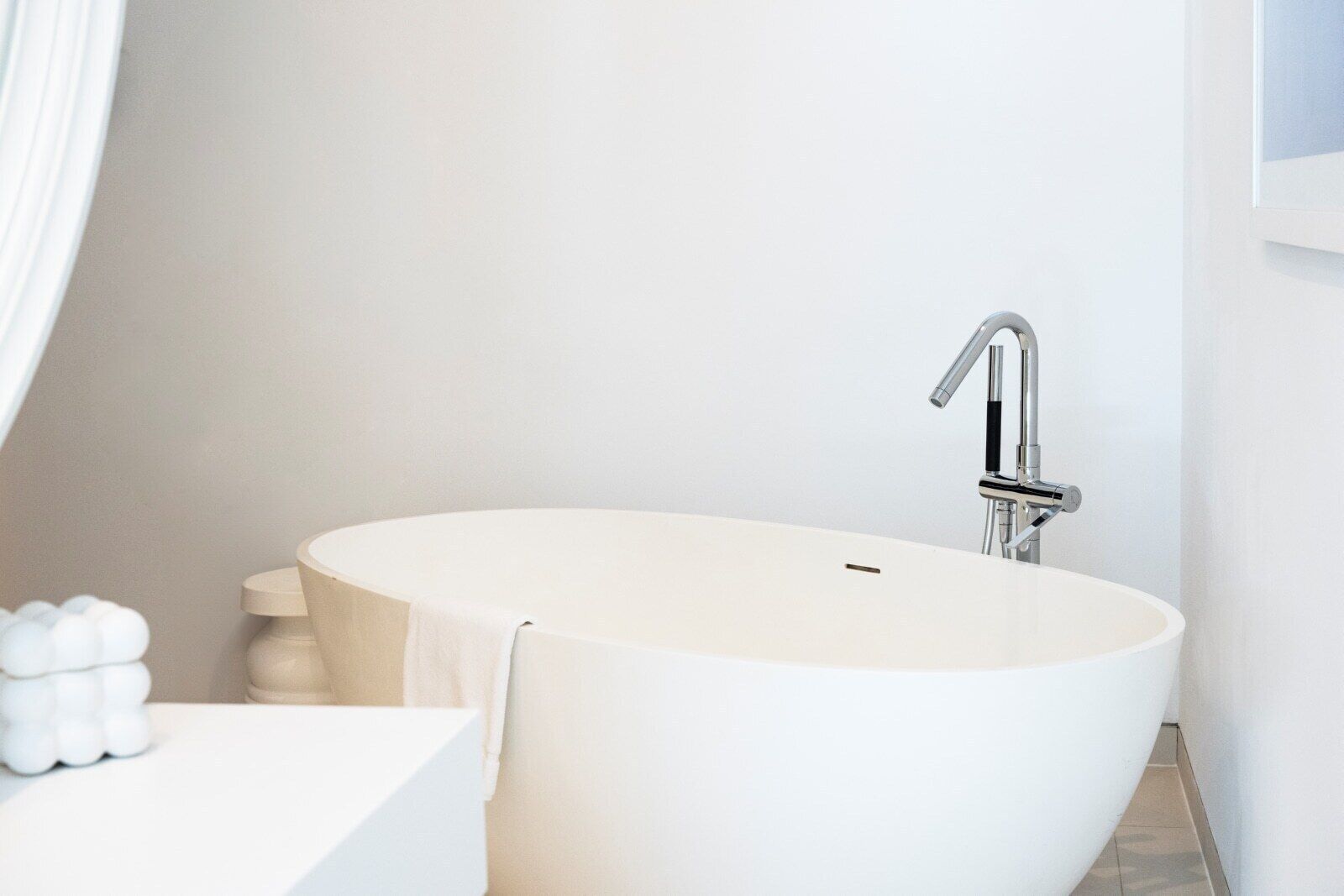 Un baño moderno con una bañera independiente, un lavabo blanco y un inodoro.