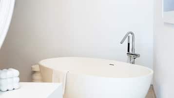 Un baño moderno con una bañera independiente, un lavabo blanco y un inodoro.