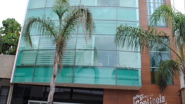 Un hotel moderno con fachada de vidrio y un letrero que dice "Hotel Centinela Grand".