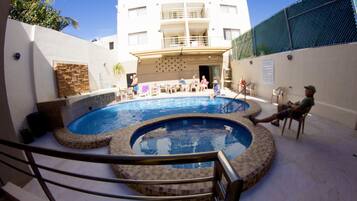 Relax by the circular pool surrounded by lounge chairs and a small table.