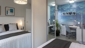 Une chambre moderne avec un grand lit, des tables de chevet, un bureau et une chaise.