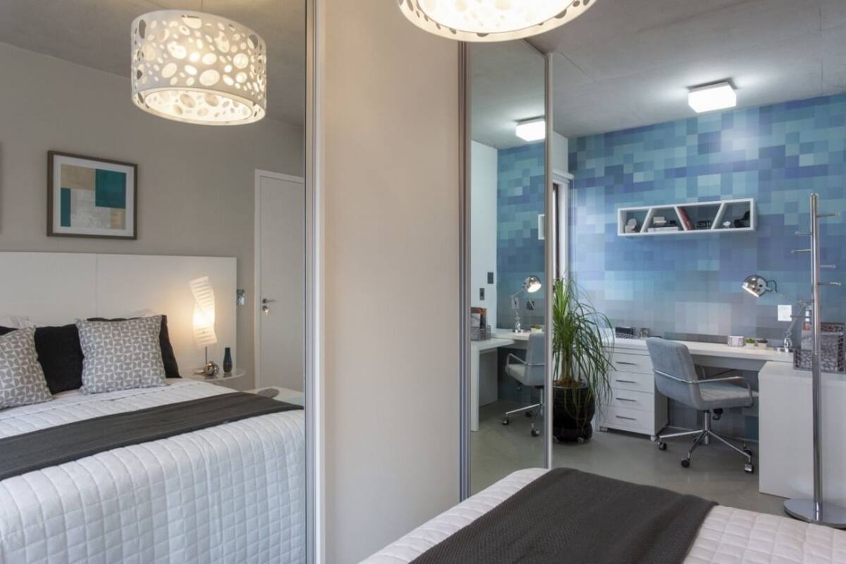 A modern bedroom with a large bed, bedside tables, a desk, and a chair.