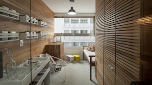 Une cuisine moderne avec des meubles en bois, un meuble-bar intégré et une grande fenêtre qui laisse entrer la lumière naturelle.