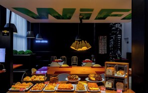 Un restaurante con mesa y sillas de madera, un letrero de neón y diversos alimentos a la vista.