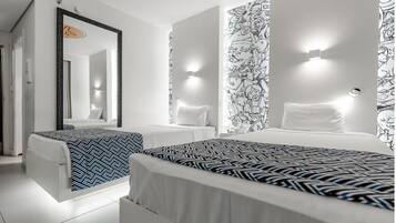 Quarto de hotel com duas camas, um espelho grande e papel de parede estampado.