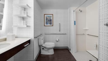 Une salle de bain moderne équipée de toilettes, d’un lavabo et d’un espace douche.