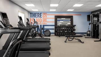 A gym with treadmills, dumbbells, and exercise equipment.