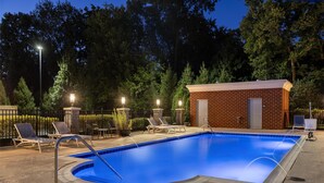 A swimming pool with lounge chairs and a small brick building, surrounded by trees and a fence. - Hampton Inn Lexington Medical Center (Lexington)