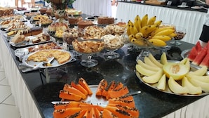 A buffet with various food items including bread, pastries, fruits, and desserts. - Hotel Central Parque (Sao Lourenco)
