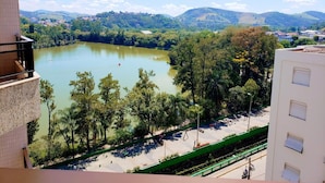 A view of a lake surrounded by trees and hills, with a building in the foreground. - Hotel Central Parque (Sao Lourenco)