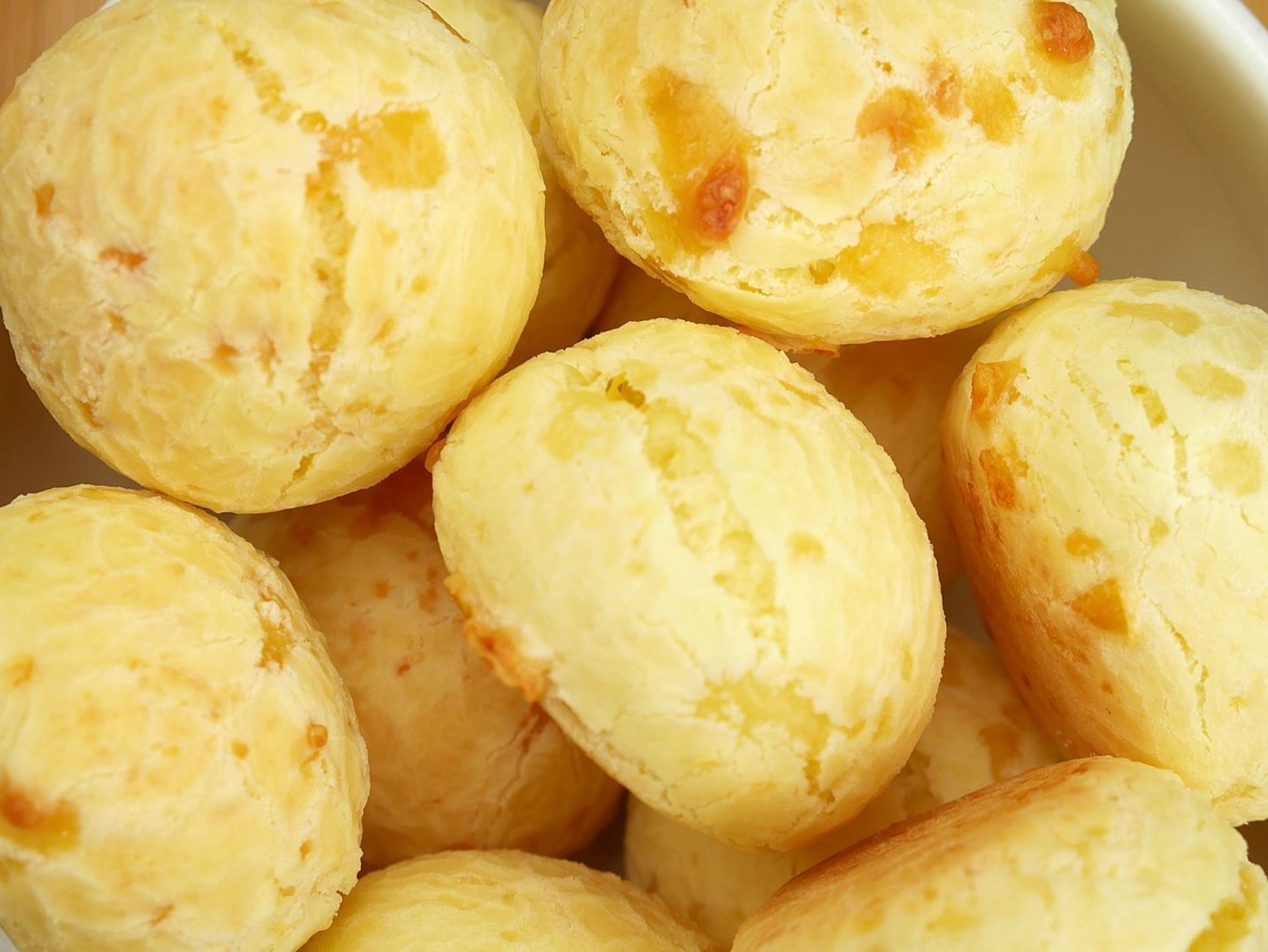 Um close-up de vários pastéis redondos e amarelos, com recheio à vista.