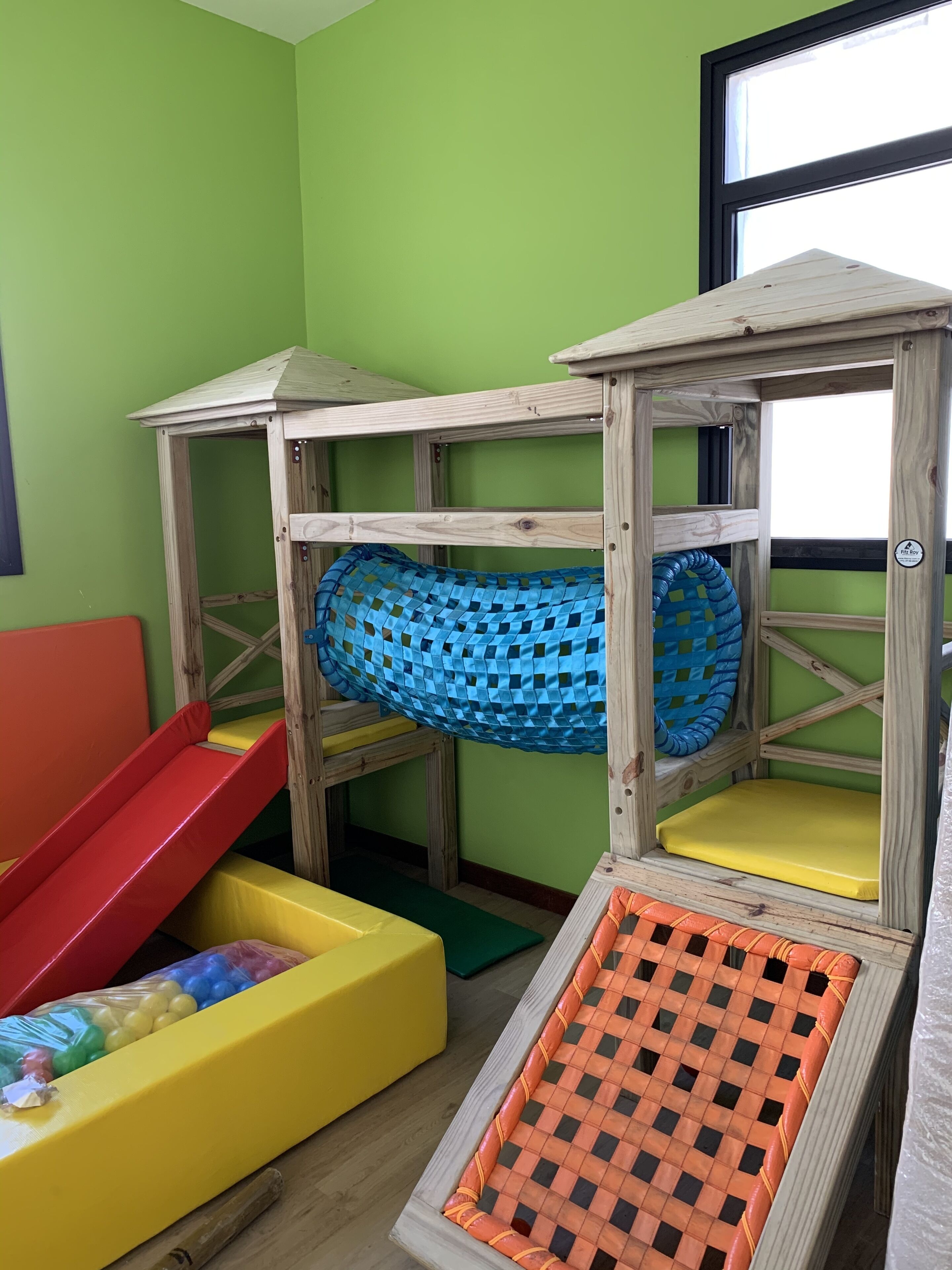 Un espace de jeux pour enfants avec des lits superposés, un toboggan et une piscine à balles.