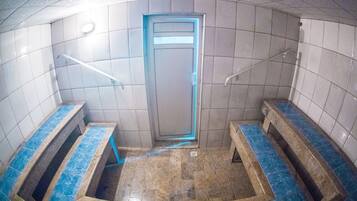 Public restroom with two benches and a door.