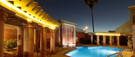 Una piscina cubierta, una piscina al aire libre, tumbonas