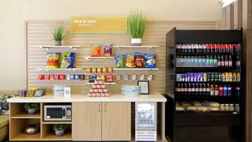 Un kiosque proposant des collations et des boissons, avec un assortiment de produits, ainsi qu’un four à micro-ondes.