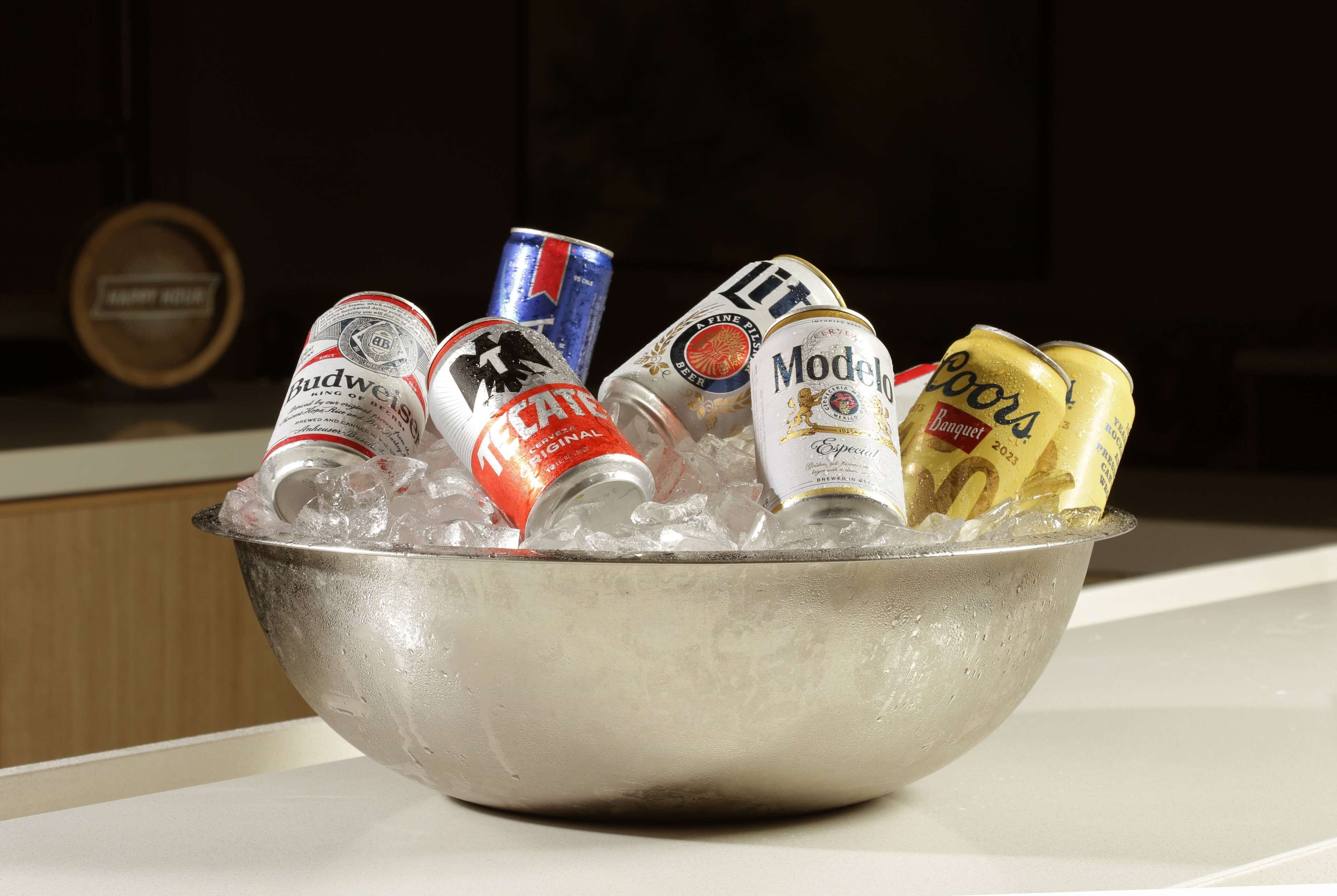 A metal bowl filled with ice and various beer cans.
