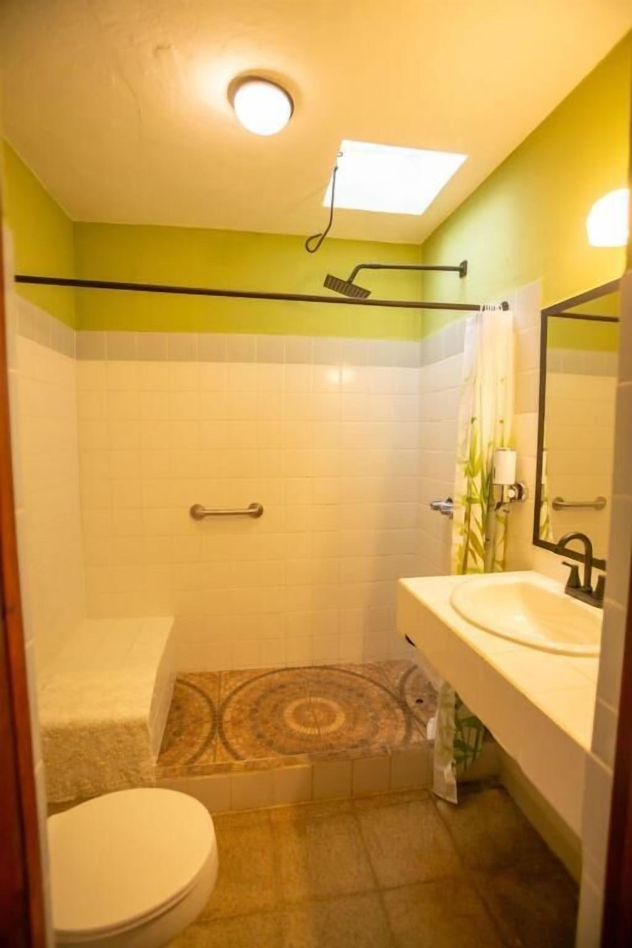A bathroom with a shower, toilet, and sink.