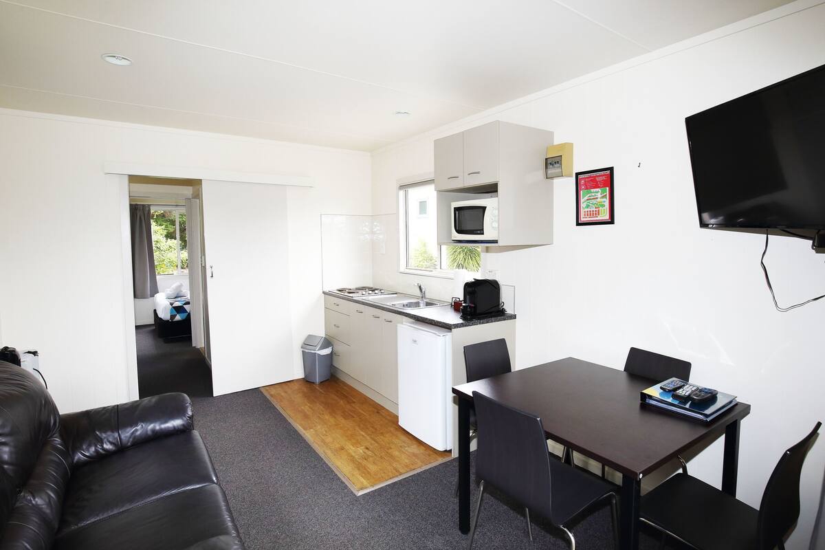 A compact living space with a kitchenette, a dining area, and a seating area.