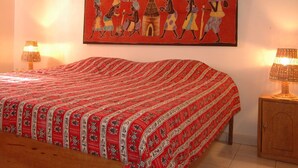 Une chambre à coucher avec un lit, deux lampes de chevet, une table de chevet en bois et un tableau mural.