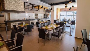 A modern restaurant with a mix of dining areas, including a bar and several tables with chairs. - Pacific Palace Beach Tower Hotel (Mazatlán)