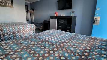 A hotel room with two beds, a desk, a TV, and a minibar.