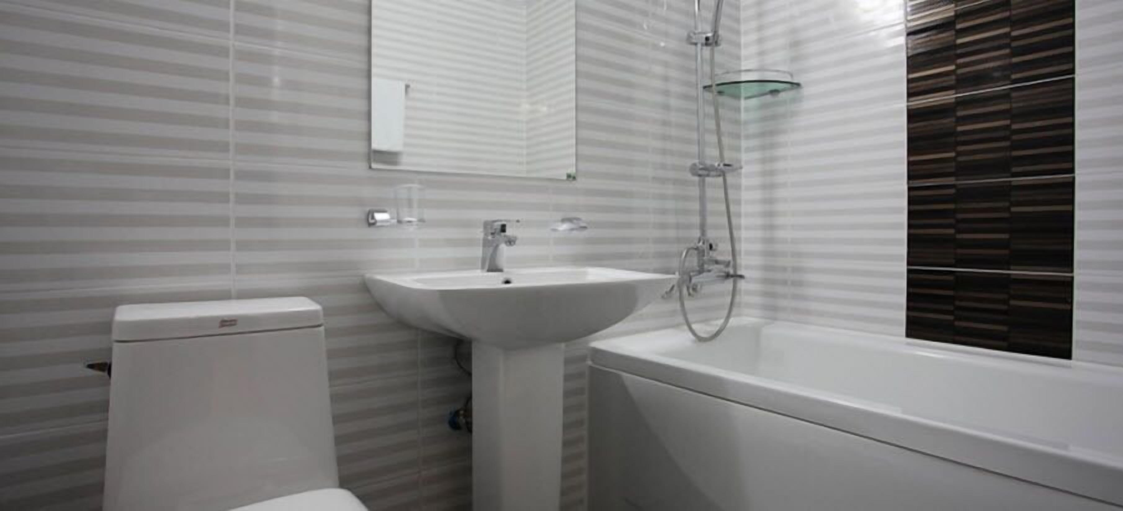 deluxe double room | bathroom | bathtub, hair dryer, slippers, towels