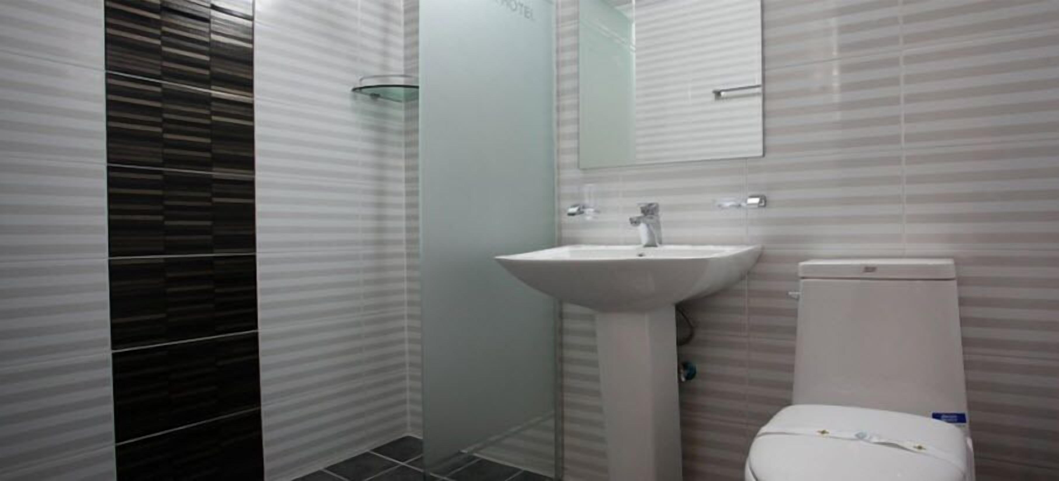 deluxe double room | bathroom | bathtub, hair dryer, slippers, towels