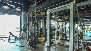 Ein Fitnessstudio mit Gewichtstrainern, Spiegeln und einem großen Fenster.