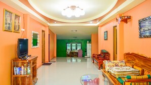 A spacious living room with a television, bookshelf, and a sofa. - Kama Siri (Ko Kood)