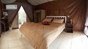 A tent-style room with a bed, a wardrobe, a bedside table, and an air conditioning unit. - Kama Siri (Ko Kood)