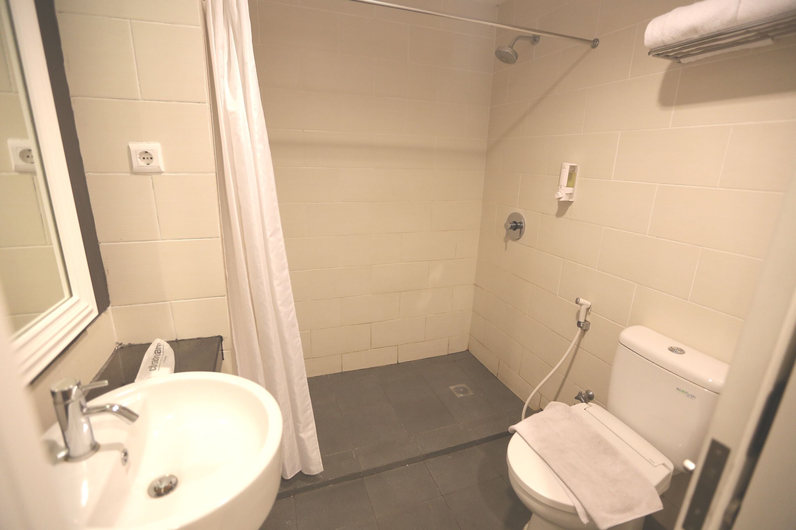 A small bathroom with a sink, toilet, and shower.