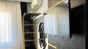A bathroom with a black and gold vanity, a mirror, and a ceiling-mounted air conditioner. - Orange Airport Hotel (Istanbul)