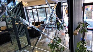 A modern interior with a glass staircase, a seating area with a sofa and armchairs, and potted plants. - Orange Airport Hotel (Istanbul)