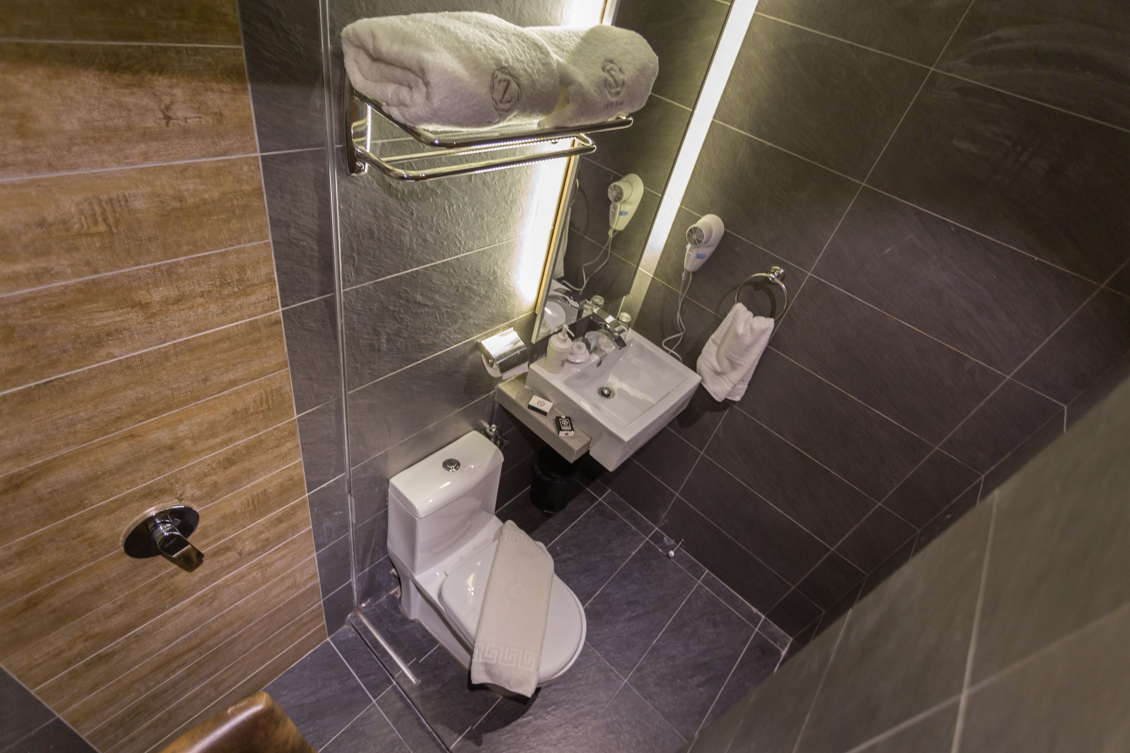 Un baño moderno con inodoro, lavamanos y toallero.