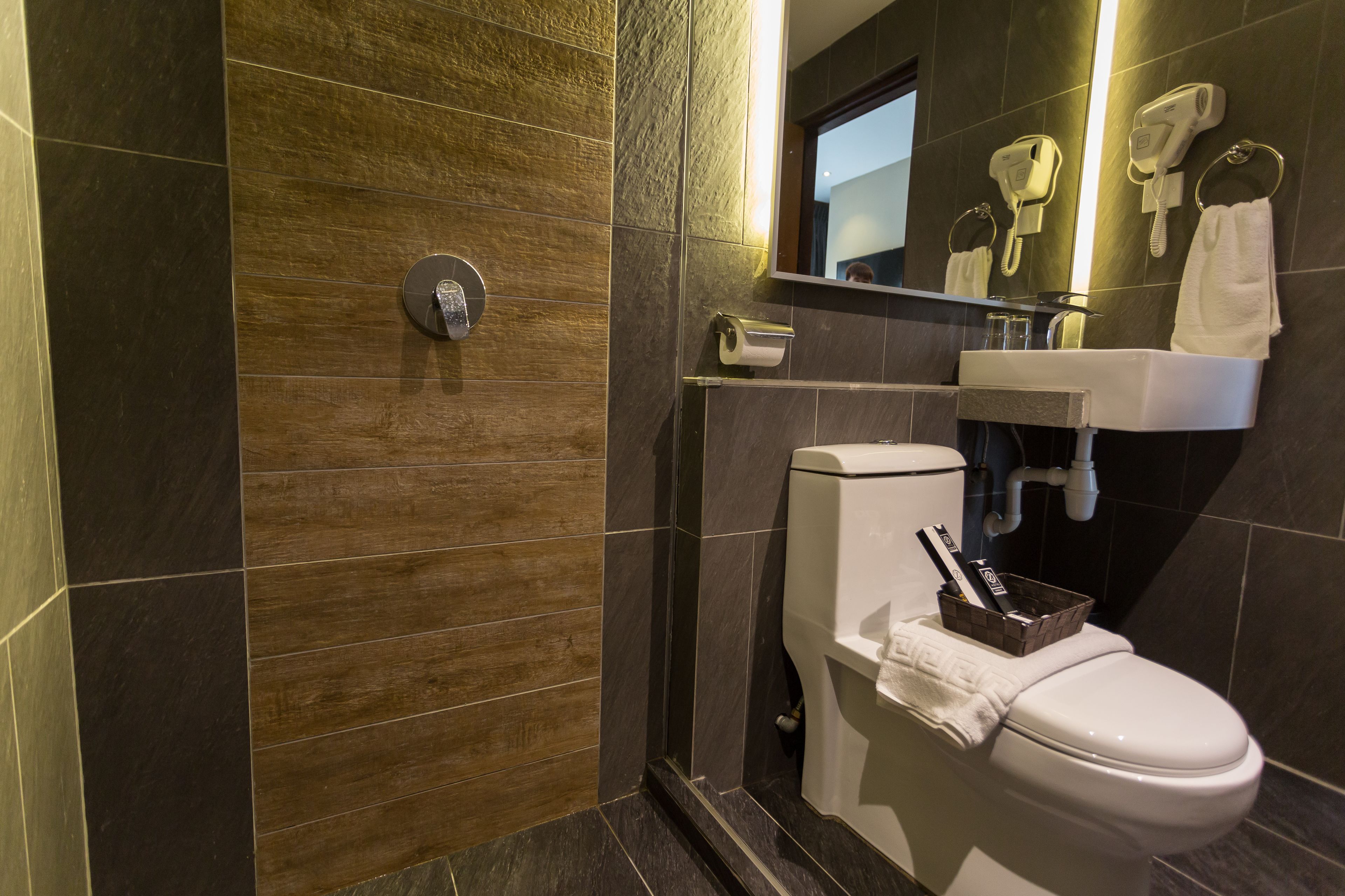 A modern bathroom with a toilet, sink, and shower.