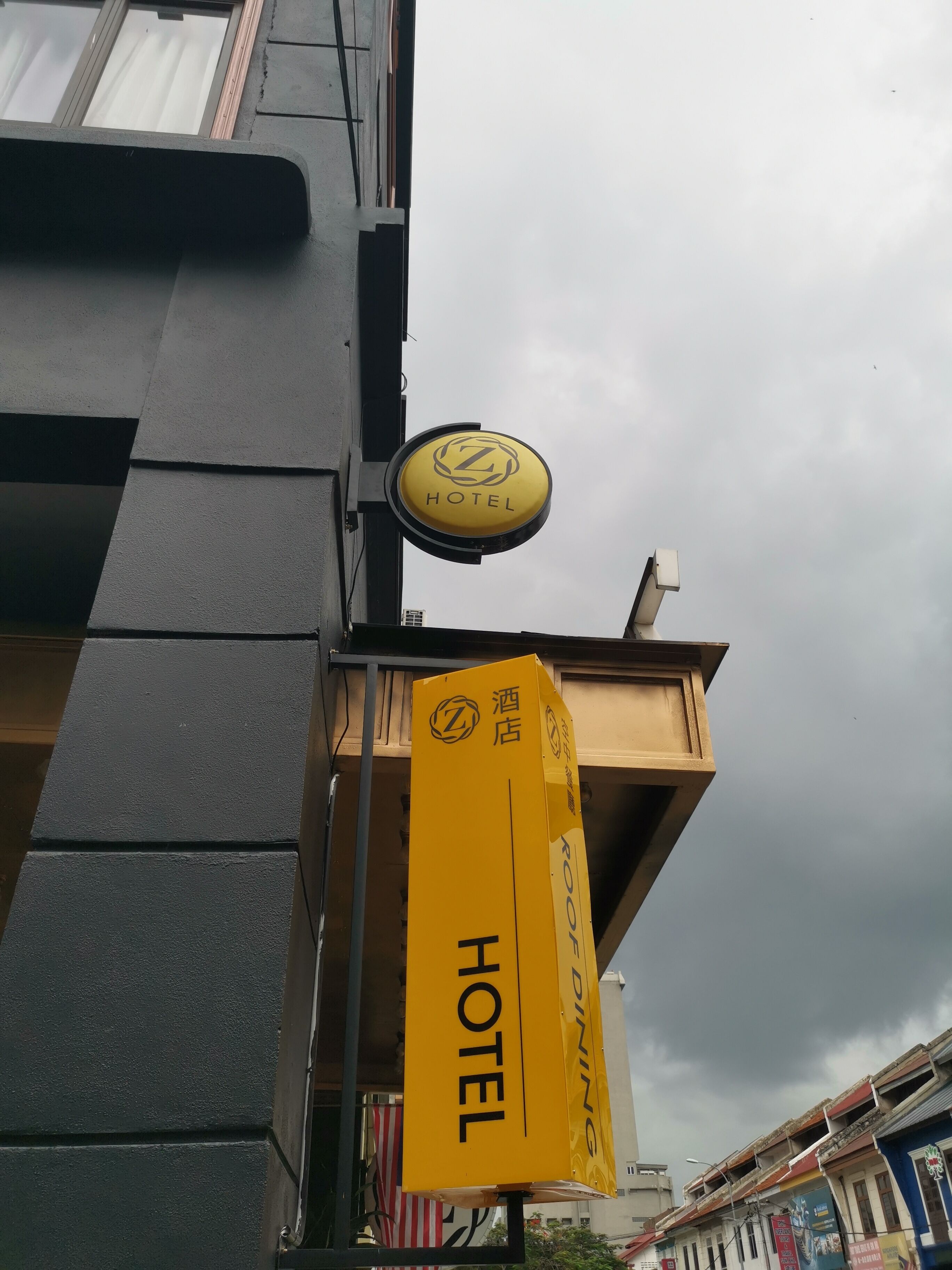 Une enseigne d’hôtel avec un logo circulaire et le mot « HÔTEL » en dessous.