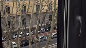 A view of a building with multiple windows and a street with parked cars. - Milizie 76 Gallery (Rome)