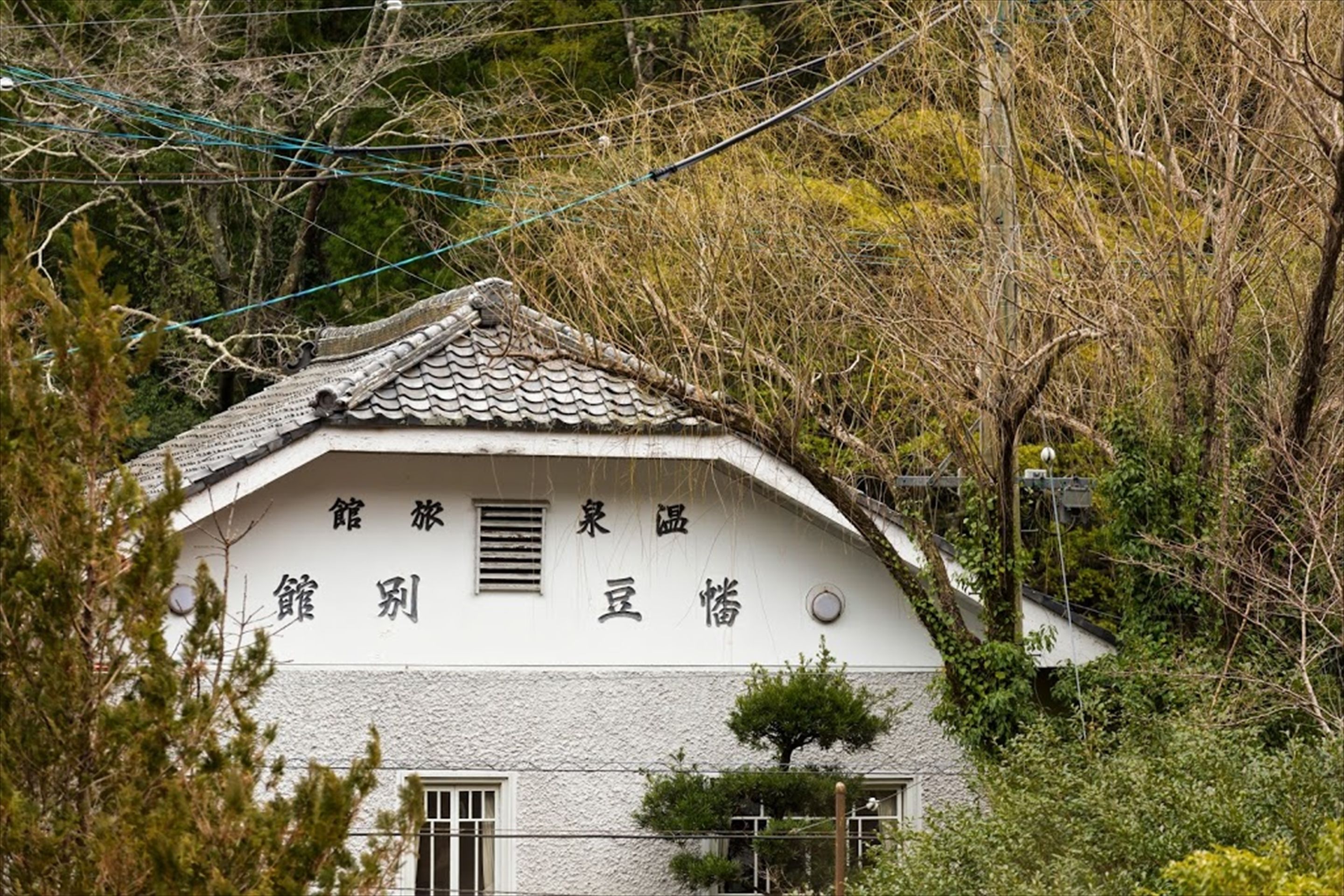 Un edificio japonés tradicional con tejado de tejas y un letrero con caracteres japoneses.