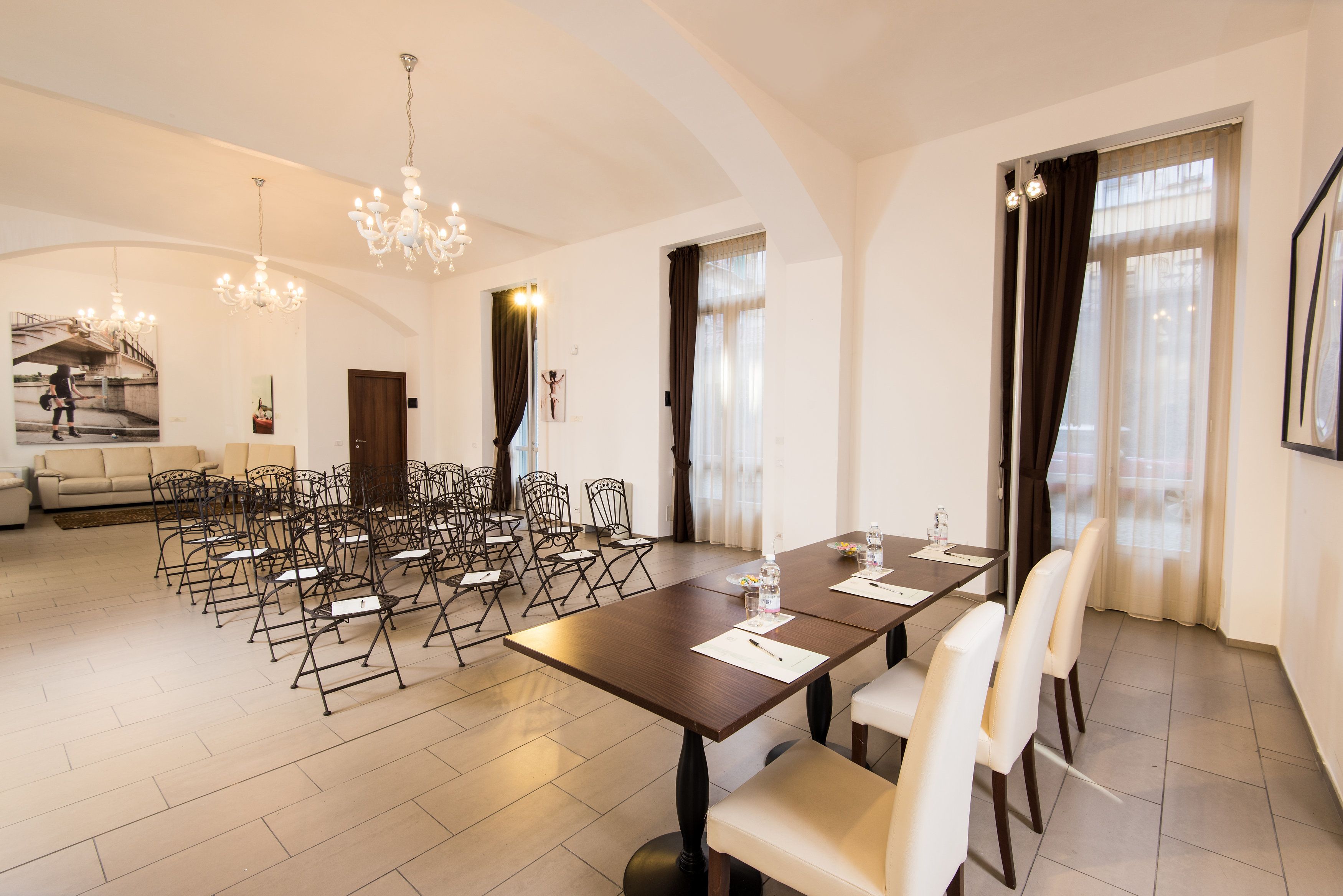 A spacious dining area with a long table, multiple chairs, and a chandelier.