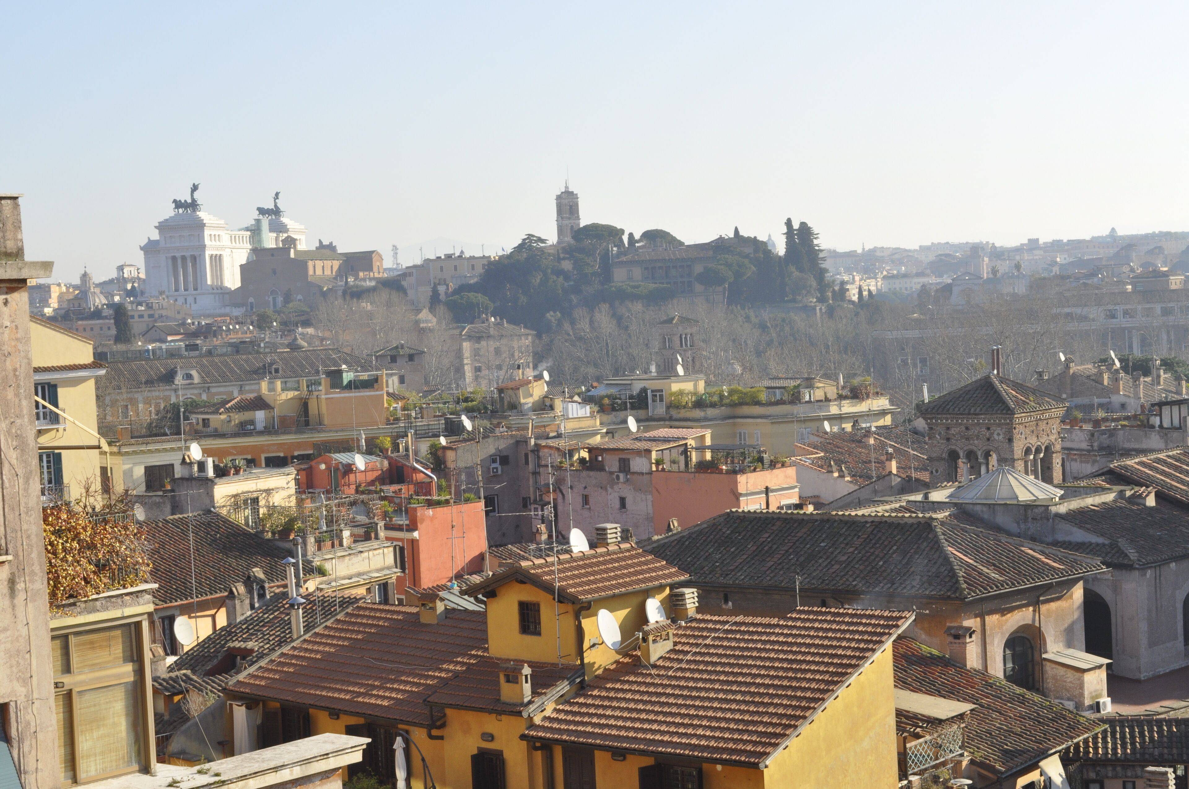 Un paysage urbain avec des bâtiments historiques, une église imposante et une construction située au sommet d’une colline.