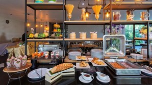 A buffet setup with various food items, including waffles, pastries, and a variety of beverages.