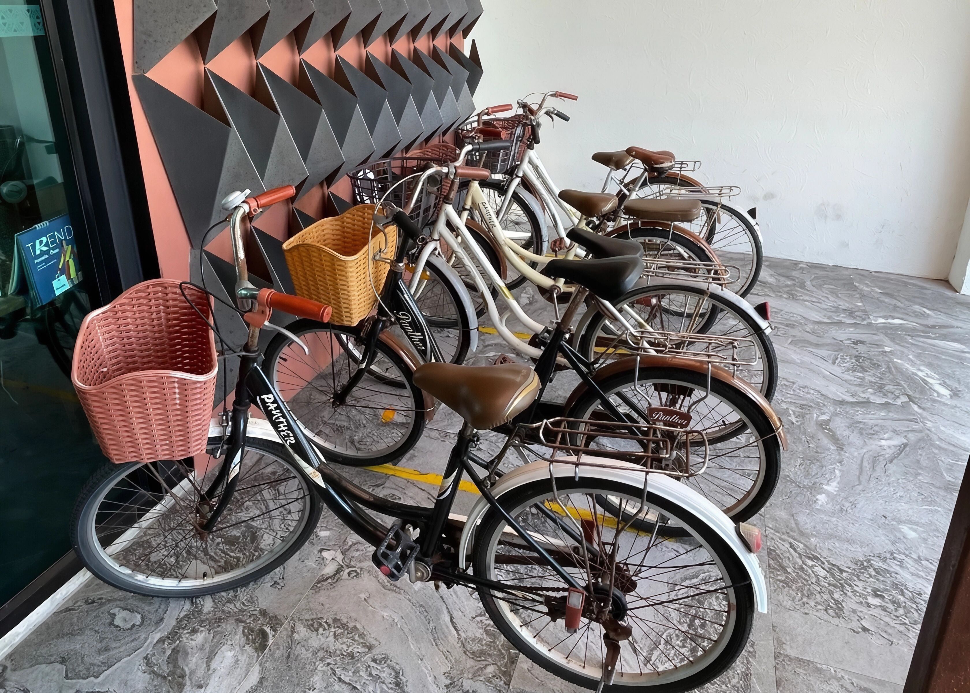 Varias bicicletas estacionadas en el interior, cada una con una cesta delantera.