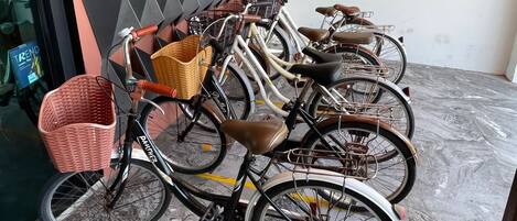 Varias bicicletas estacionadas en el interior, cada una con una cesta delantera.