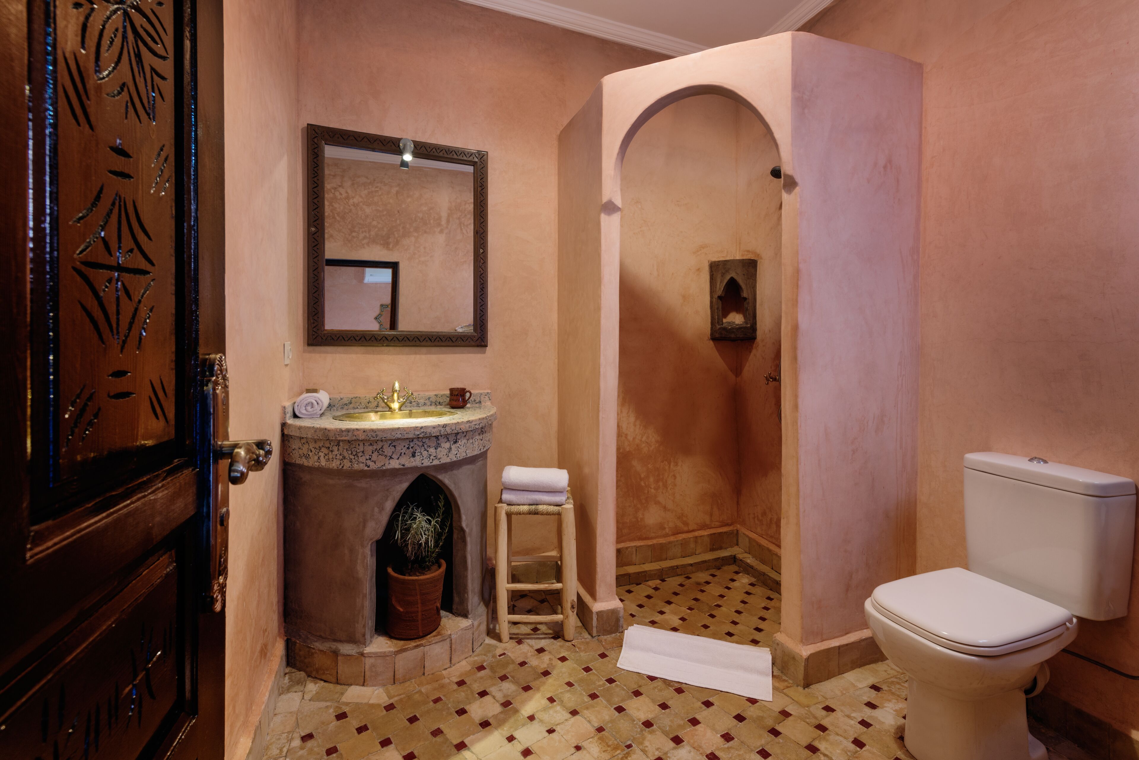 Ein Badezimmer mit Marmorwaschbecken, Toilette und Duschbereich.
