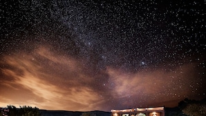 Un hôtel doté d’une piscine, d’un espace extérieur aménagé et offrant une vue sur le ciel étoilé.