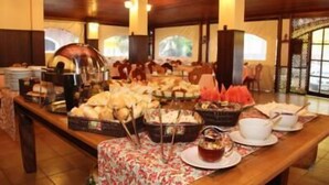 Een buffetopstelling met diverse gerechten en een theeservies.