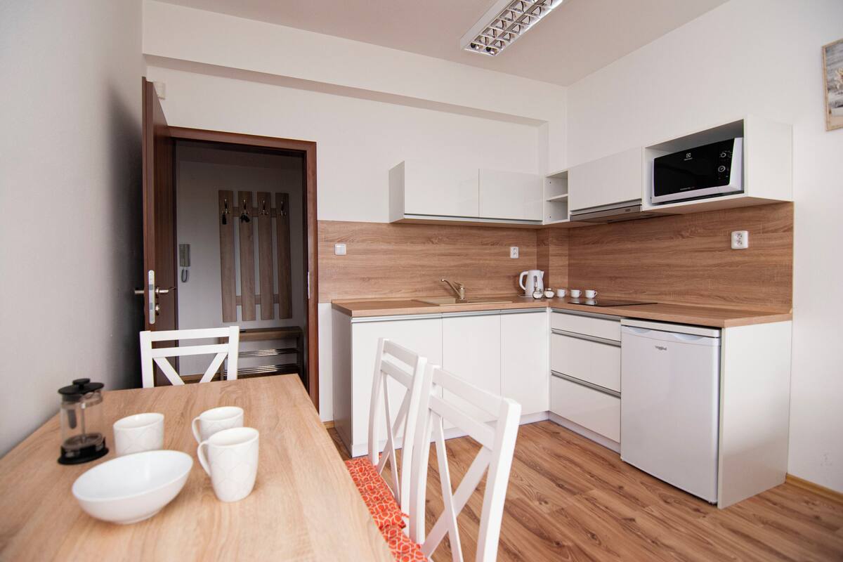 A compact kitchen with white cabinetry, a microwave, and a dishwasher.