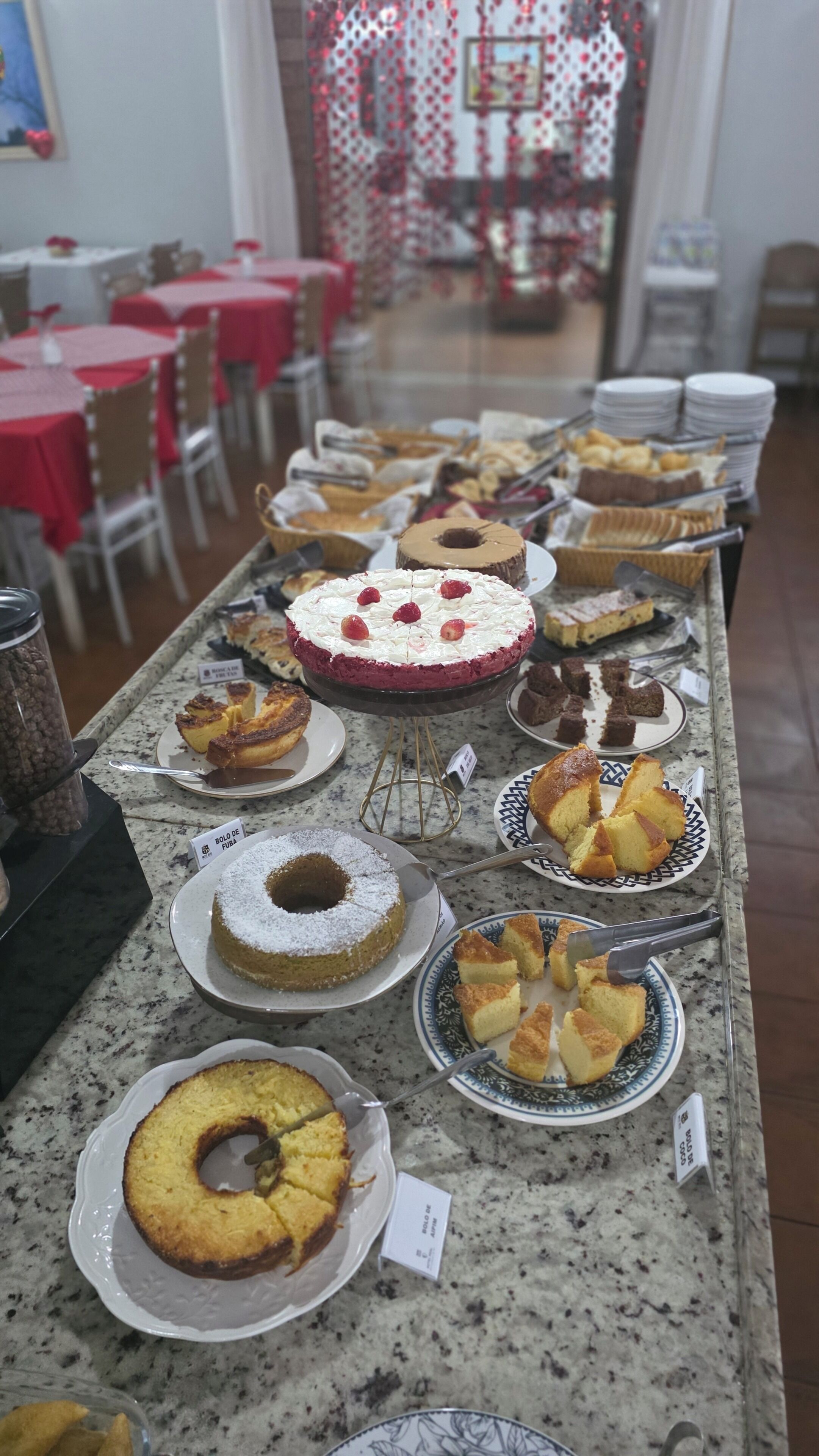 A buffet table with various cakes and pastries.